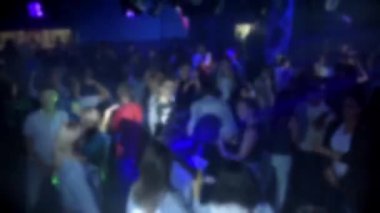 bir gece kulübünde dans eden insanların bir kalabalığın bulanık siluetleri