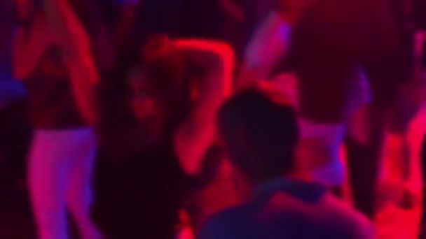 Vage silhouetten van een groep dansende mensen op de dansvloer in een nachtclub — Stockvideo
