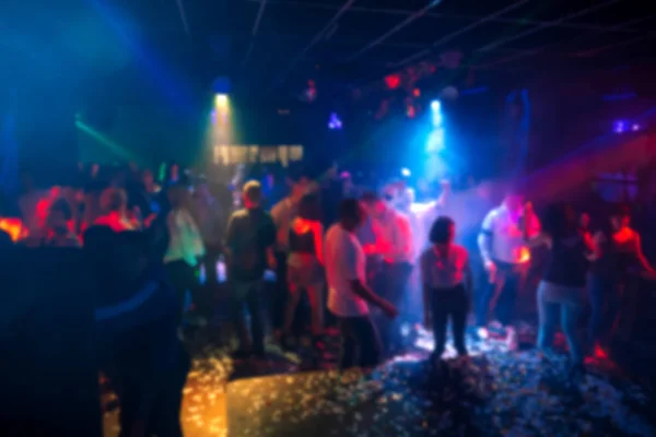 Silhouetten van een menigte van mensen dansen in een nachtclub op de dansvloer op een feestje — Stockfoto