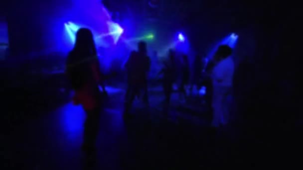 Розмиті силуети людей, що танцюють у нічному клубі на танцмайданчику на музичному концерті — стокове відео