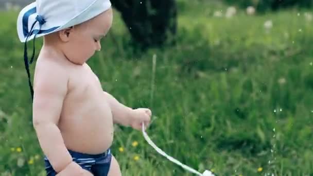 Divertido pequeño niño jugando y salpicando en el prado con burbujas de jabón — Vídeos de Stock