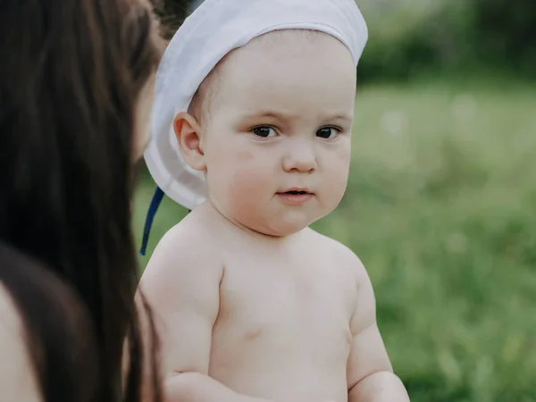 Menino nas mãos de sua mãe no verão em um prado — Fotografia de Stock