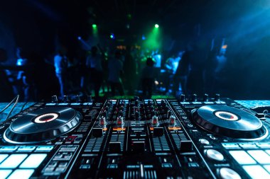 Dans insanların bulanık bir arka plan üzerinde bir gece kulübünde bir kabinde Dj müzik karıştırıcı