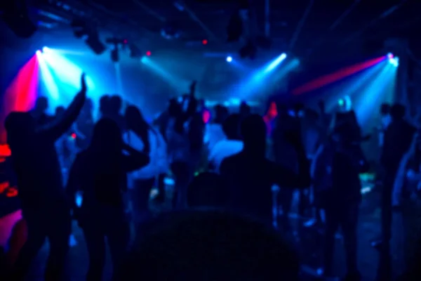 Silhouettes d'une foule de personnes dansant dans une boîte de nuit sur la piste de danse lors d'une fête — Photo