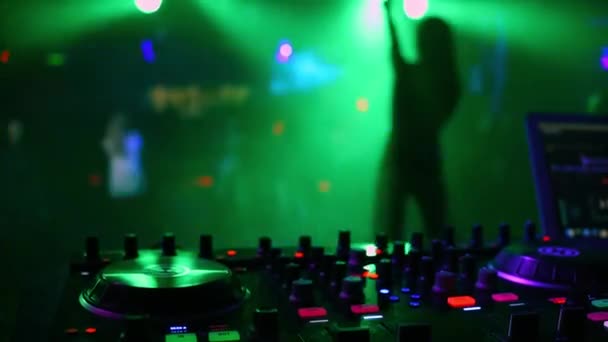 DJ controller mixer in nightclub with blurred silhouette of dancing girl singer — Stock Video