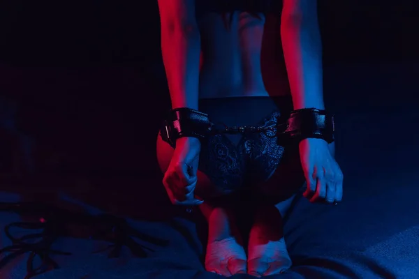 Sexig röv undergiven flicka handbojor på sängen med läder piska för BDSM sex — Stockfoto