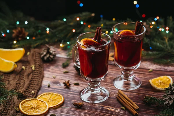 两只玻璃杯，酒上覆满一层木桌，上面有冷杉枝条，新年来临了 — 图库照片