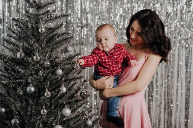 Anne ve küçük oğlu Noel ağacı arka plan üzerinde