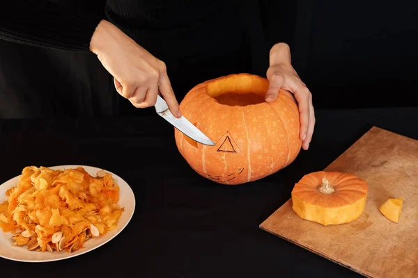 Jacks Halloween dyni. Dziewczyny ręka z nożem cięcie pomarańczowy dyni — Zdjęcie stockowe