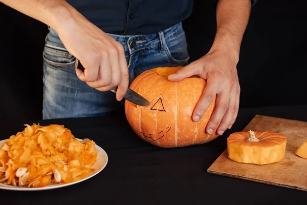 Jacks Halloween pumpkin. Hands of a man with a knife cutting orange pumpkin — Stock Photo, Image