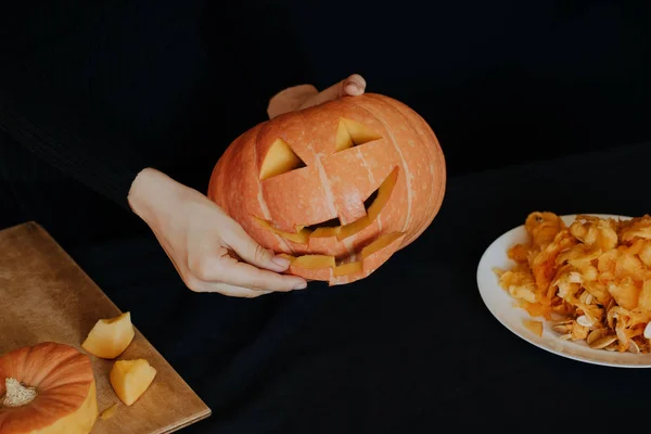 Dziewczyna ręce sprawia, że pomarańczowy dyni na Halloween. Przygotowanie latarni Jack — Zdjęcie stockowe