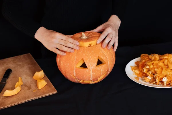 Dziewczyna ręce sprawia, że pomarańczowy dyni na Halloween. Przygotowanie latarni Jack — Zdjęcie stockowe