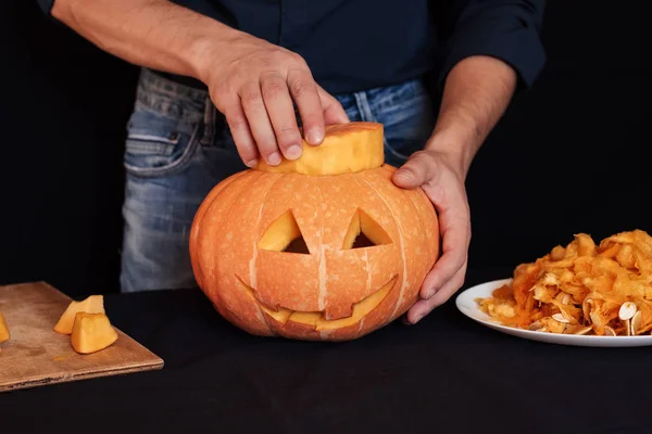 Człowiek sprawia, że pomarańczowy dyni na Halloween — Zdjęcie stockowe