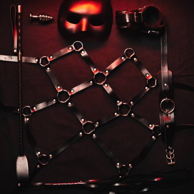 Kırbaç, kelepçe, maske, BDSM kemer, boyun eğme ve egemenlikle seks için anal tıpa