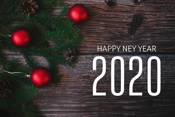 Zimní přání s textem Šťastný Nový rok 2020 s jedlovými větvemi a červenými míčky — Stock fotografie