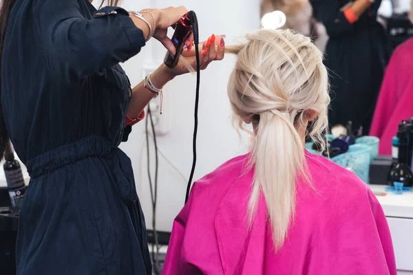 Penteado bun para uma menina loira com cabelo longo — Fotografia de Stock