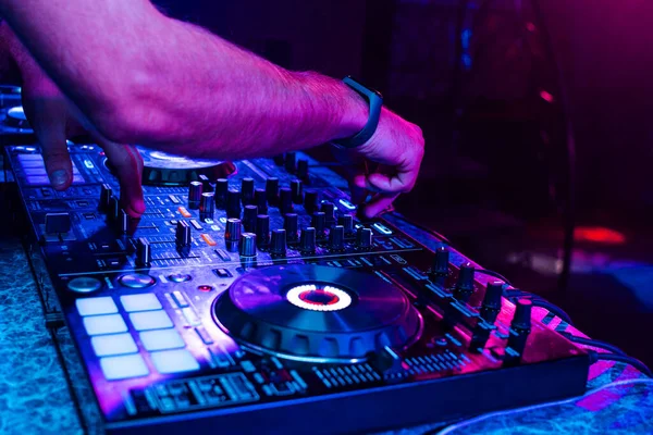 Hände eines DJs, der Musik auf einem professionellen Controller in einer Kabine mixt — Stockfoto