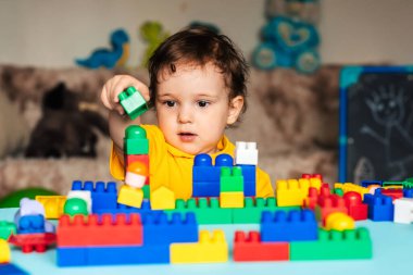 Çocuk bloklardan ev yapmayı öğreniyor.