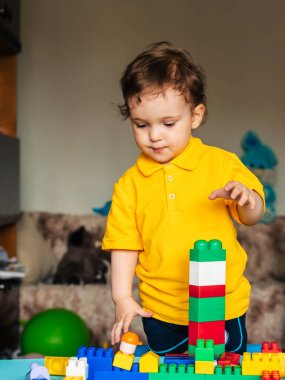 Evde renkli küplerle oynayan sevimli küçük bir çocuk.