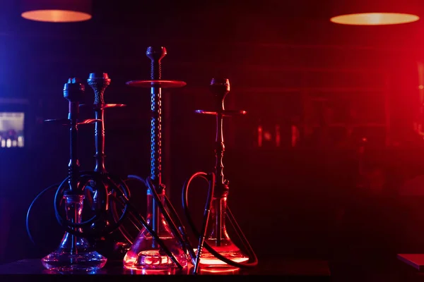 Hookahs with glass flasks and metal bowls on the table in the restaurant for traditional Eastern Turkish relaxation — Stock Photo, Image