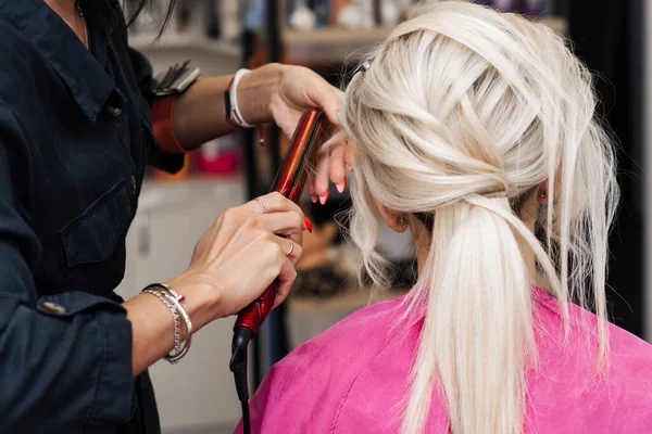 Penteado bun para uma menina loira com cabelo longo — Fotografia de Stock