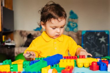 Evde renkli küplerle oynayan sevimli bir çocuk.