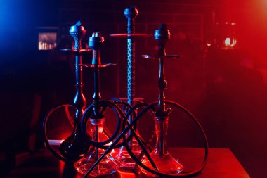 Kafenin iç tarafındaki masanın üzerinde shisha kaseleri ve kömürleri olan hookahlar.