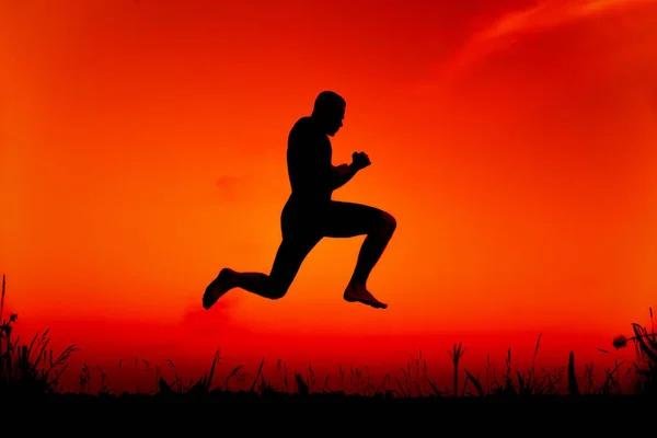 Silhouette d'un gymnaste masculin effectuant un entraînement de saut dans la nature — Photo