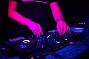 DJ, elektronik müzikle müzik kumandasını karıştırıyor.