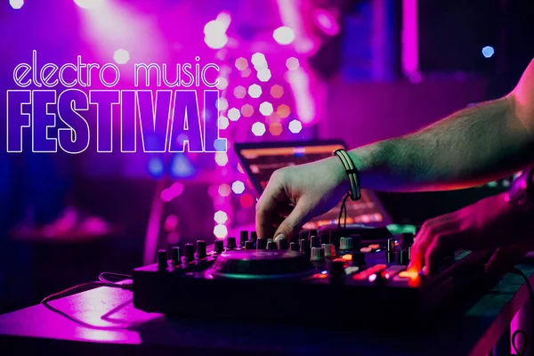 Aufschrift Elektro-Musik-Festival auf dem Hintergrund der Hände eines DJ, der Musik auf einem Mischpult mixt — Stockfoto