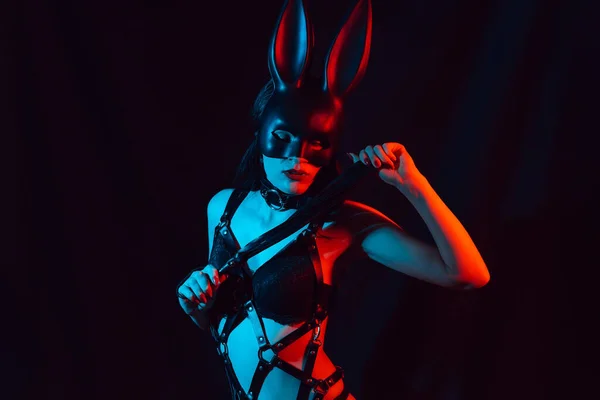 Сексуальная молодая девушка в маске кролика в нижнем белье с кожаным ремнем с кнутом — стоковое фото