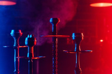 Geleneksel Arap rahatlaması için restoranın masasındaki tabakta shisha kömürlü hookahlar.