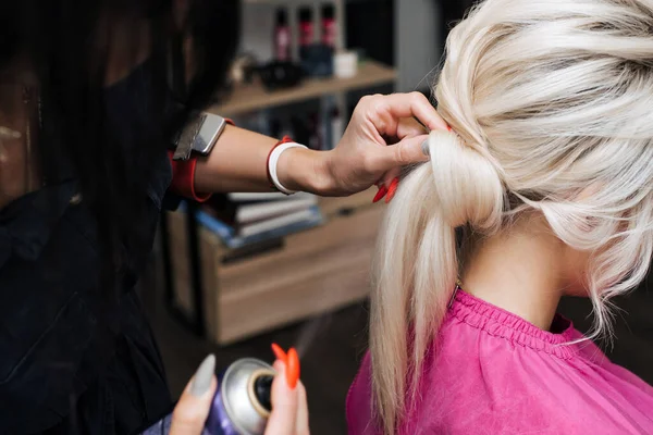 Penteado bun para uma menina loira com cabelo longo — Fotografia de Stock