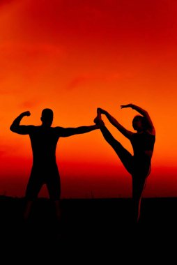 Sportif çift birlikte spor antrenmanı ve esneme hareketleri yapıyor.