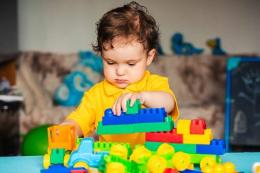 Çocuk evde küplerle oynuyor.