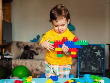 Evde renkli küplerle oynayan sevimli küçük bir çocuk.