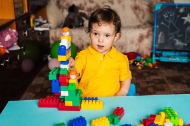 Çocuk evde küplerle oynuyor.