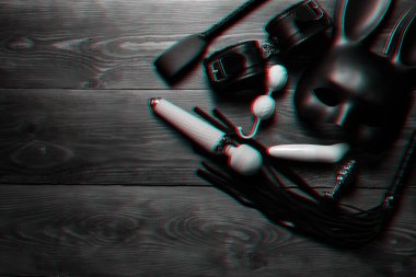 Silikon vibratör ve vajinal toplar, deri kamçı ve maske ve kemerle kelepçeler.