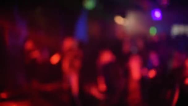 Siluetas borrosas de una multitud de personas bailando en la pista de baile en un club nocturno — Vídeo de stock