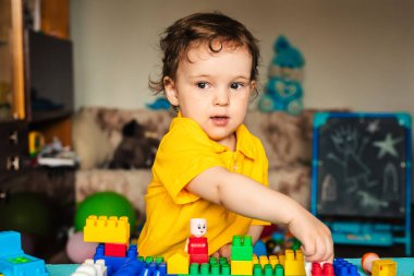 Çocuk evde küplerle oynuyor.