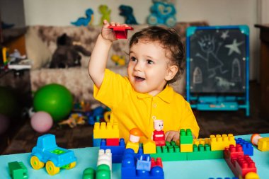 Mutlu çocuk bloklardan ev yapmayı öğreniyor.