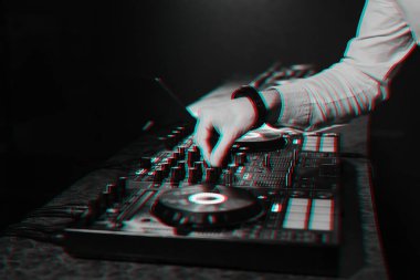DJ, elektronik müzikle müzik kumandasını karıştırıyor.