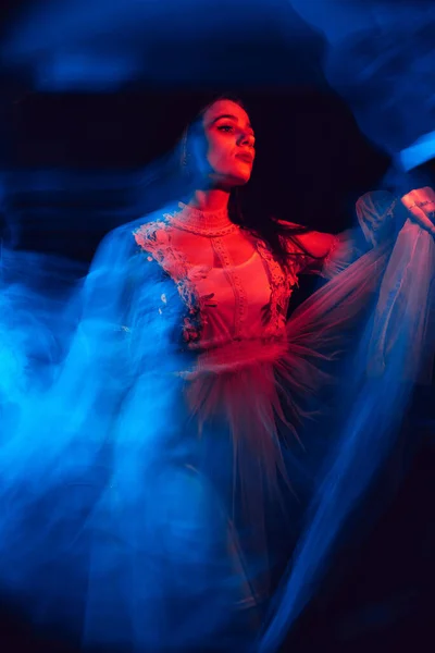 blurry abstract portrait of a young dancing girl in a dress on a black background