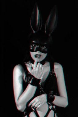 BDSM seksi için kelepçelenmiş uysal kız dudaklarına dokunuyor.