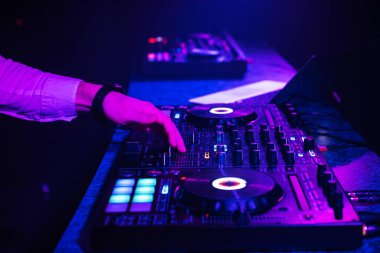 DJ, elektronik müzikle müzik kumandasını karıştırıyor.