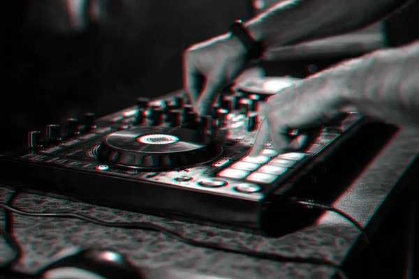 在夜总会的一场音乐会上，DJ在混音器的控制台上播放当代电子音乐 — 图库照片