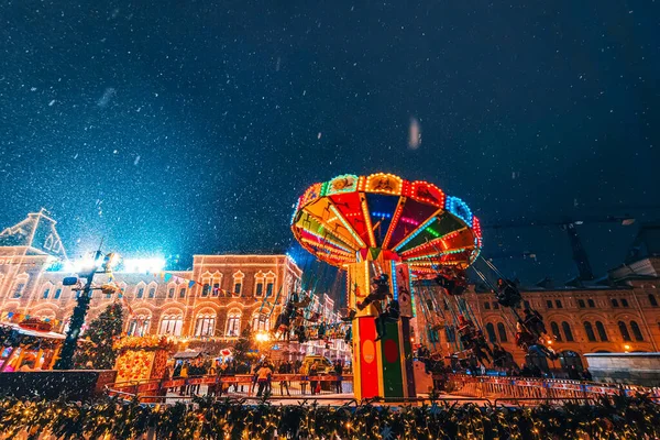 MOSCOW, Oroszország - JANUÁR 31, 2020: Körhinta piros téren díszített karácsonyi díszek Moszkvában az emberek éjjel télen — Stock Fotó