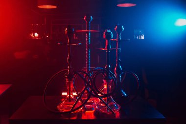 Kafenin iç tarafındaki masanın üzerinde shisha kaseleri ve kömürleri olan hookahlar.