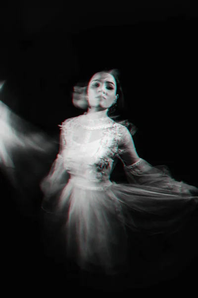 Abstrakt porträtt av en spökflicka i en vit klänning på en mörk bakgrund med suddig — Stockfoto