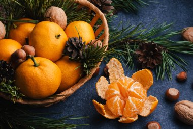 Noel dalları ve kozalaklarla süslenmiş fındık, ceviz ve mandallar.